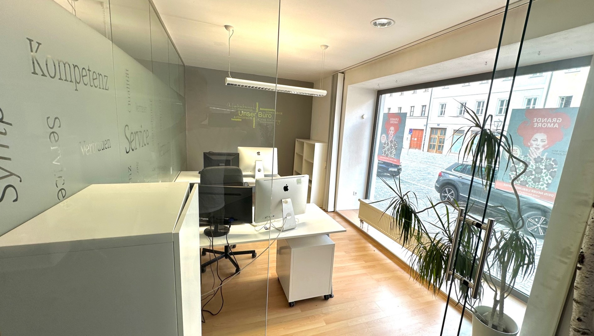 Moderner Arbeitsplatz mit Apple Computern und großen Fenstern